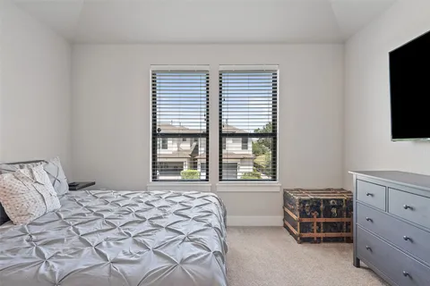 a bedroom with a bed and a flat tv screen in it