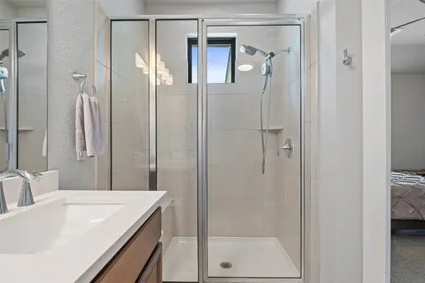 a bathroom with a tub sink vanity and mirror