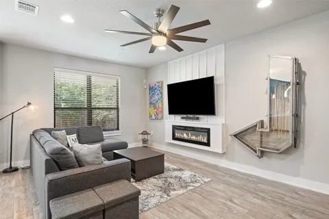 a living room with furniture a flat screen tv and a fireplace