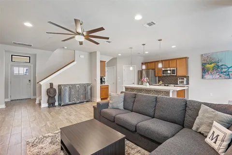 a living room with furniture and a ceiling fan