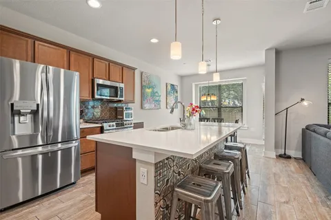 a kitchen with granite countertop a table chairs microwave and refrigerator