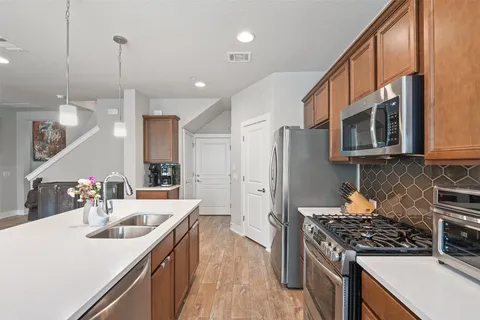 a kitchen with stainless steel appliances a sink stove and refrigerator