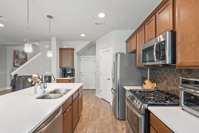a kitchen with stainless steel appliances a sink stove and refrigerator