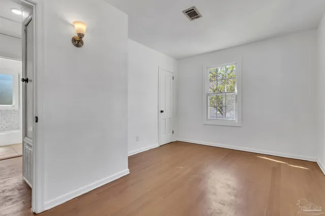 an empty room with windows and closet