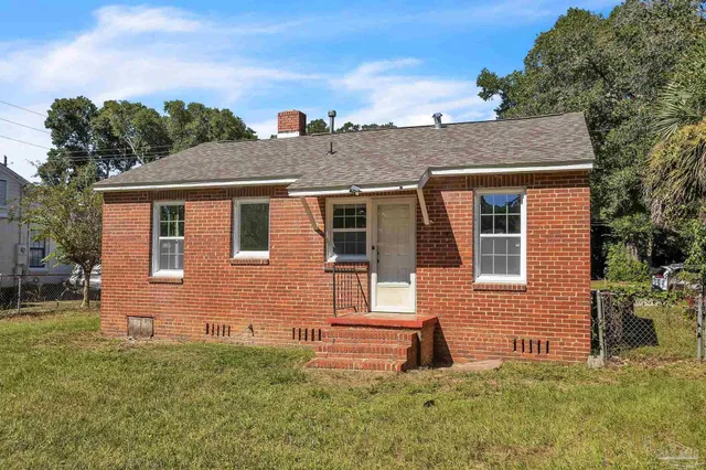 a front view of a house with a yard and trees