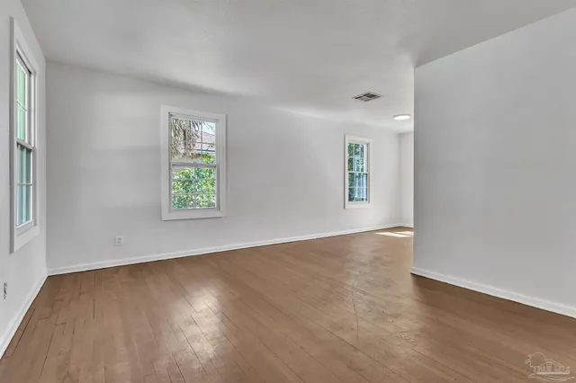 an empty room with wooden floor and a window