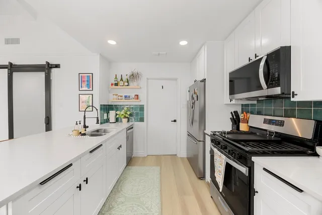 a kitchen with a sink stove and refrigerator