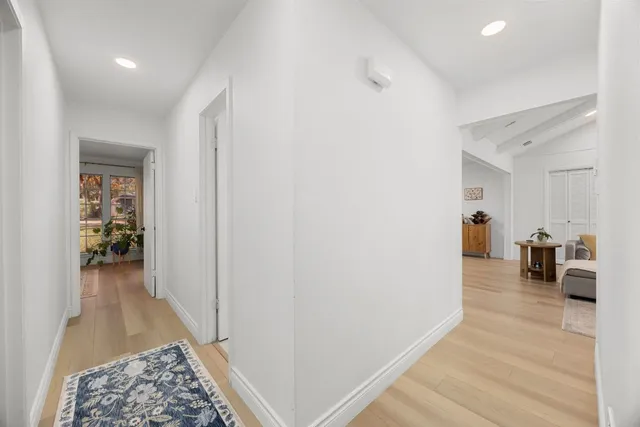 a hallway with wooden floor closet and a bathroom