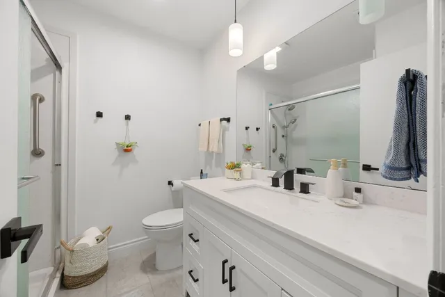 a bathroom with a double vanity sink toilet and shower