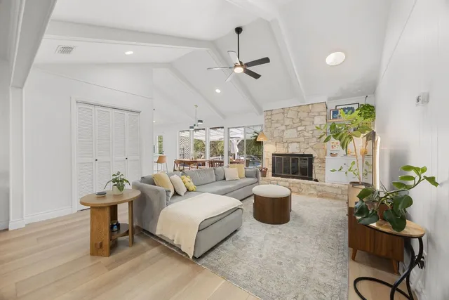 a living room with furniture a fireplace and a chandelier