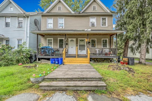 a front view of a house with swimming pool and sitting area