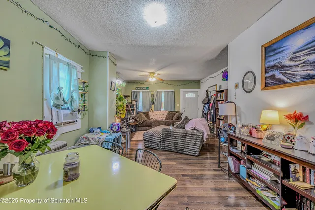 a living room with furniture and a bookshelf with wooden floor