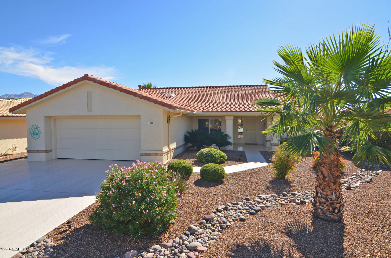1330 East Crown Ridge Drive Tucson, AZ 85755 - Photo 1 of 22 a front view of a house with a garden
