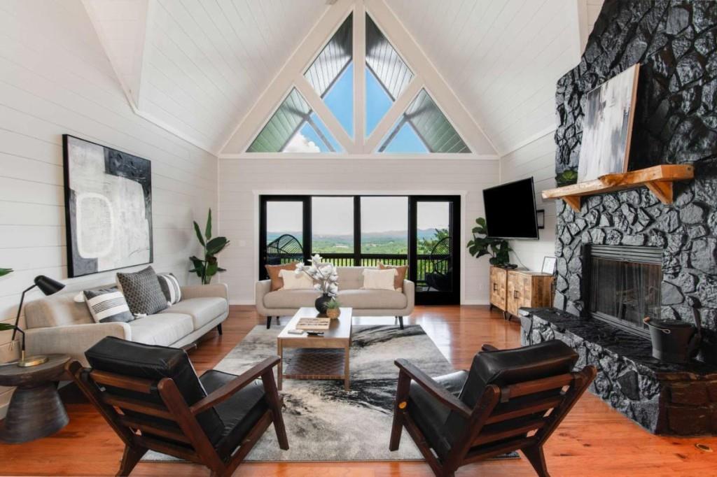 231 Sunrock Mountain Trail Blue Ridge, GA 30513 - Photo 12 of 61 a living room with furniture a fireplace and a large window