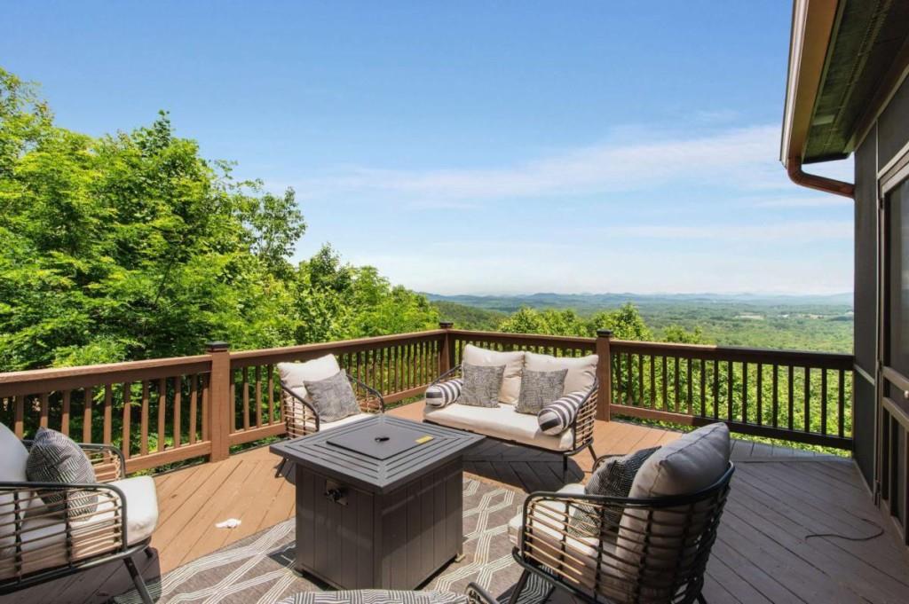 231 Sunrock Mountain Trail Blue Ridge, GA 30513 - Photo 25 of 61 a balcony with wooden floor table and chairs