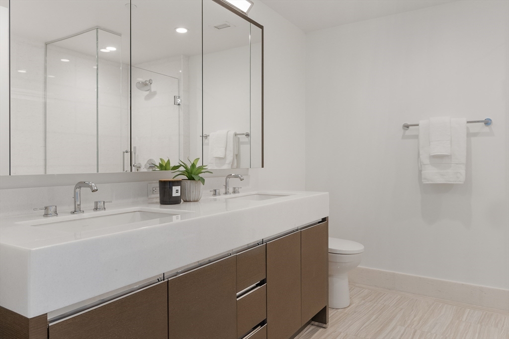 100 Lovejoy Wharf, Unit 11C Boston, MA 02114 - Photo 11 of 29 a bathroom with a sink a toilet and a mirror