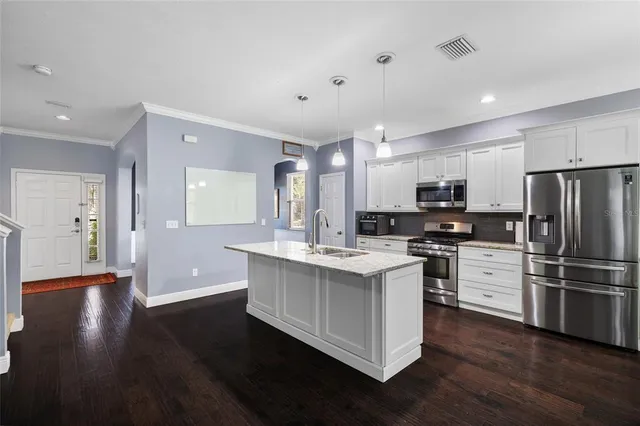 a kitchen with stainless steel appliances a dining table and chairs