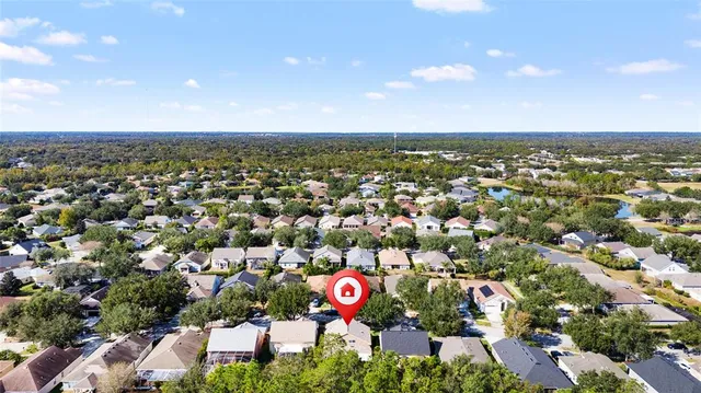 a view of swimming pool with outdoor seating and trees in the background