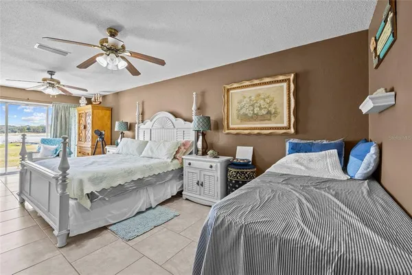 a spacious bedroom with a bed and a flat screen tv