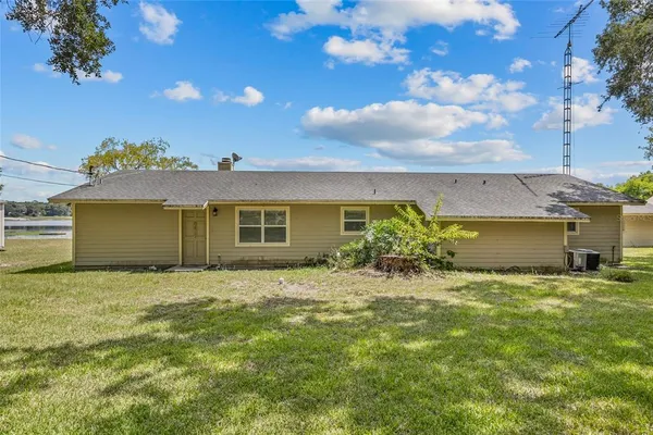 a kitchen with granite countertop cabinets a sink a stove and dining table with wooden floor