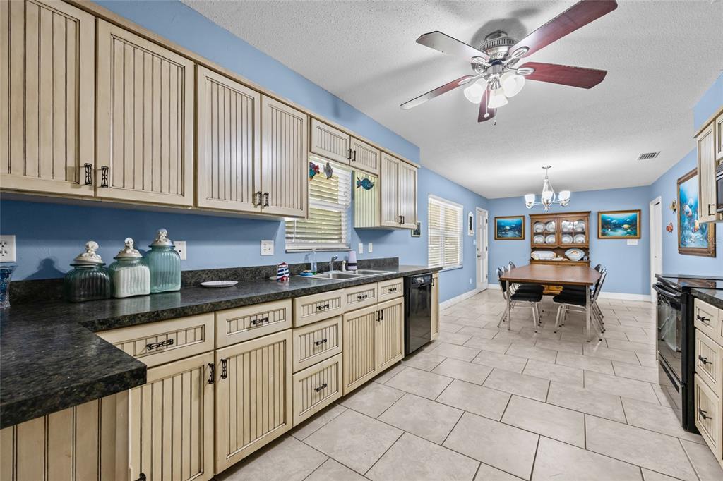6417 Baker Road Keystone Heights, FL 32656 - Photo 5 of 32 a kitchen with granite countertop cabinets a sink a stove and dining table with wooden floor