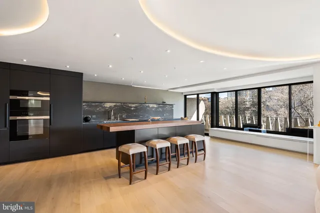 a dining room with furniture and a floor to ceiling window