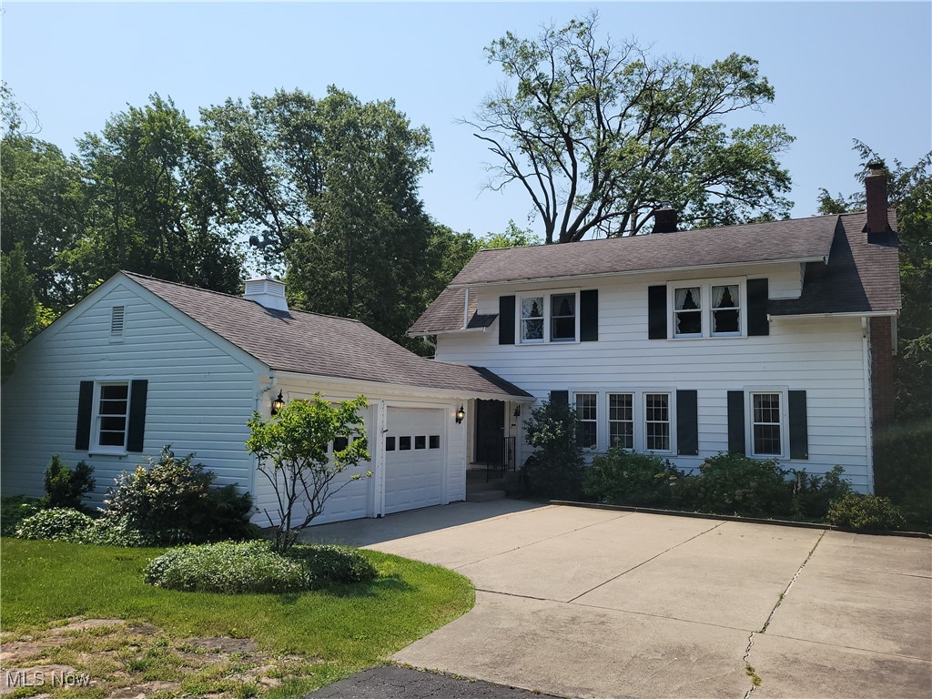 29119 Edgewood Road Bay Village, OH 44140 - Photo 1 of 40 Colonial house featuring a garage, concrete driveway, and a chimney