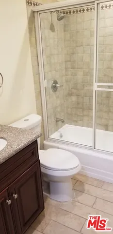 a bathroom with a granite countertop bathtub toilet and sink