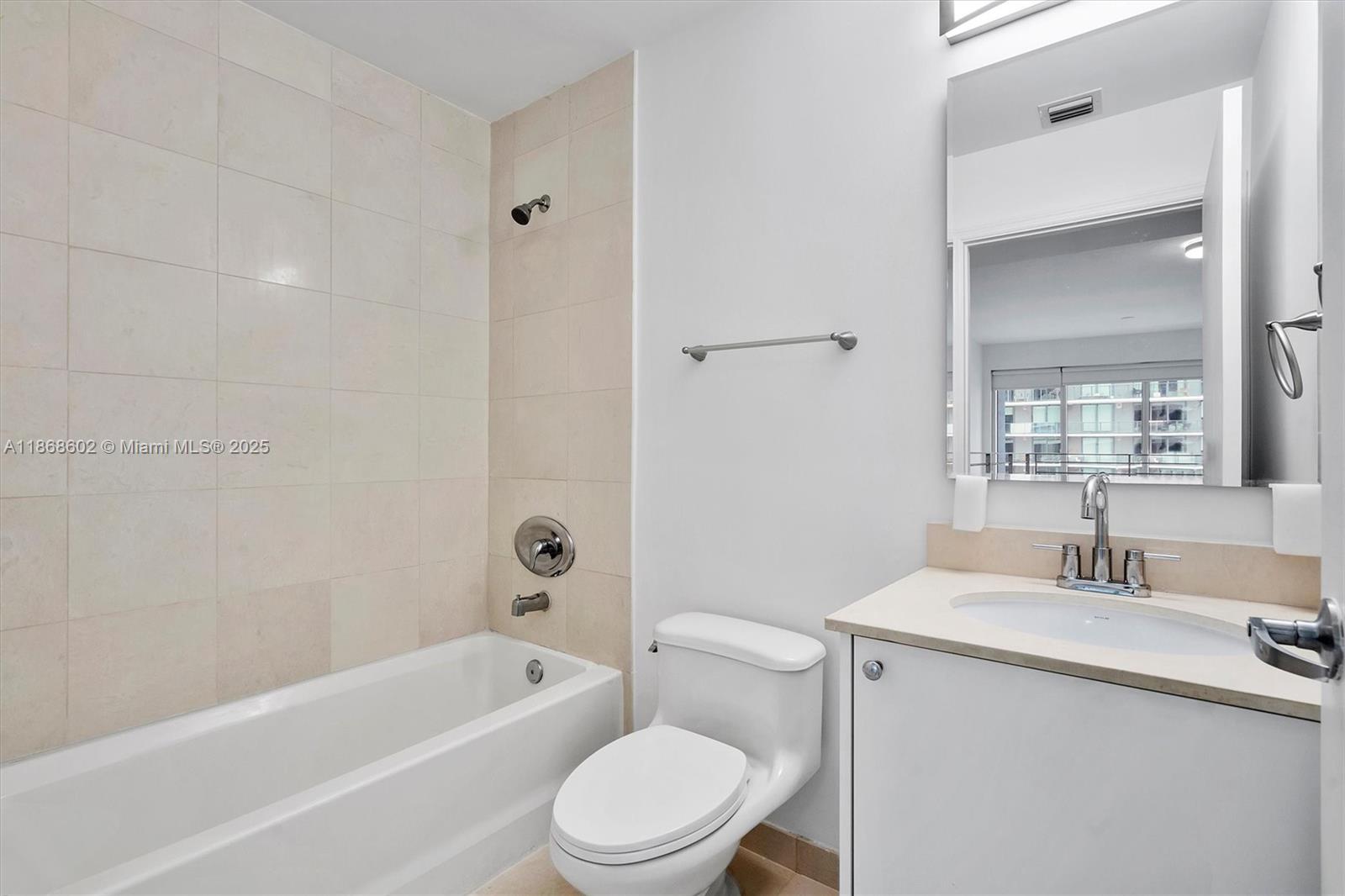 60 Southwest 13th Street, Unit 2420 Miami, FL 33130 - Photo 18 of 33 a bathroom with a toilet a sink a mirror a bathtub and vanity