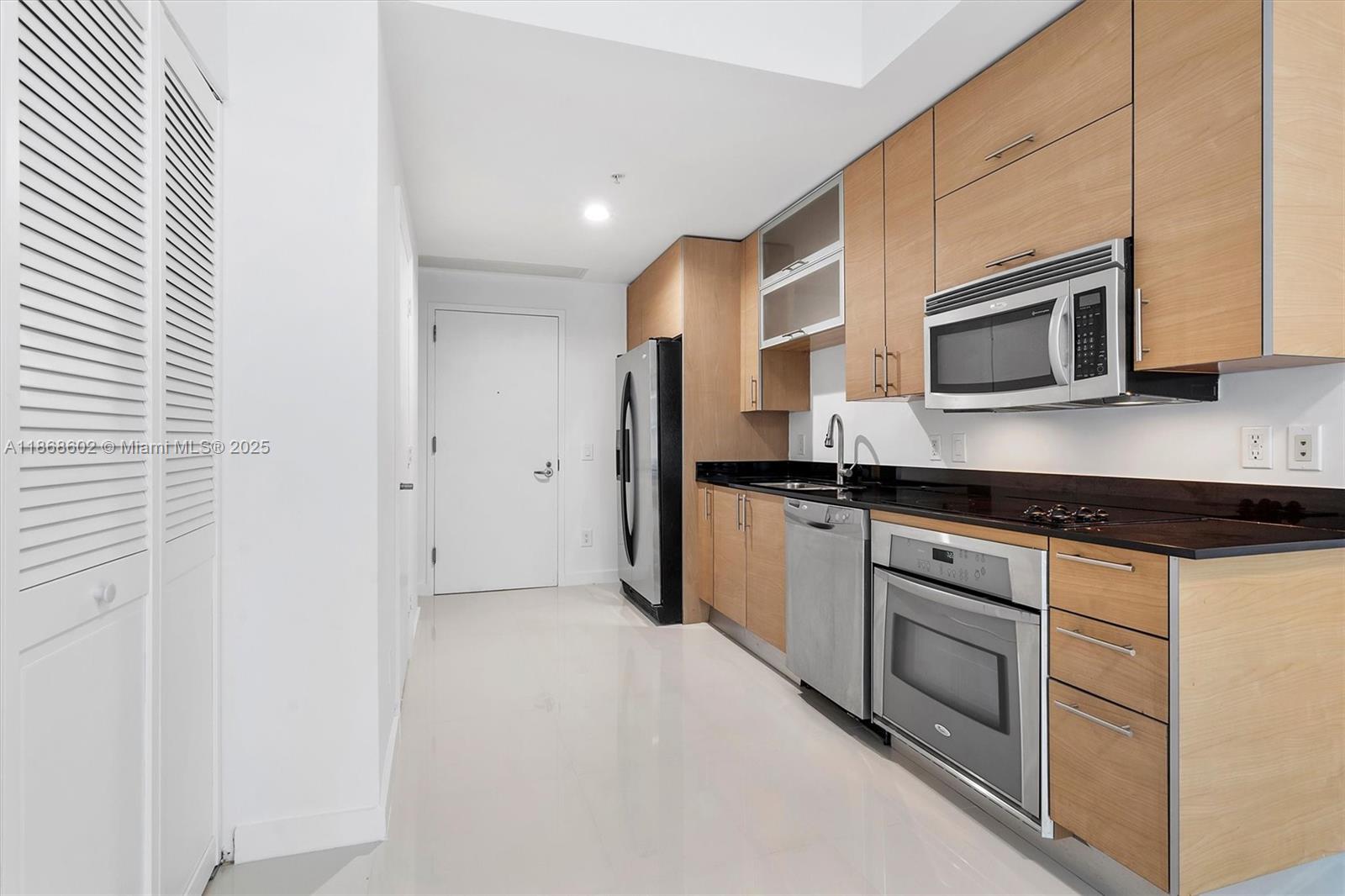 60 Southwest 13th Street, Unit 2420 Miami, FL 33130 - Photo 5 of 33 a kitchen with stainless steel appliances granite countertop a stove and a microwave