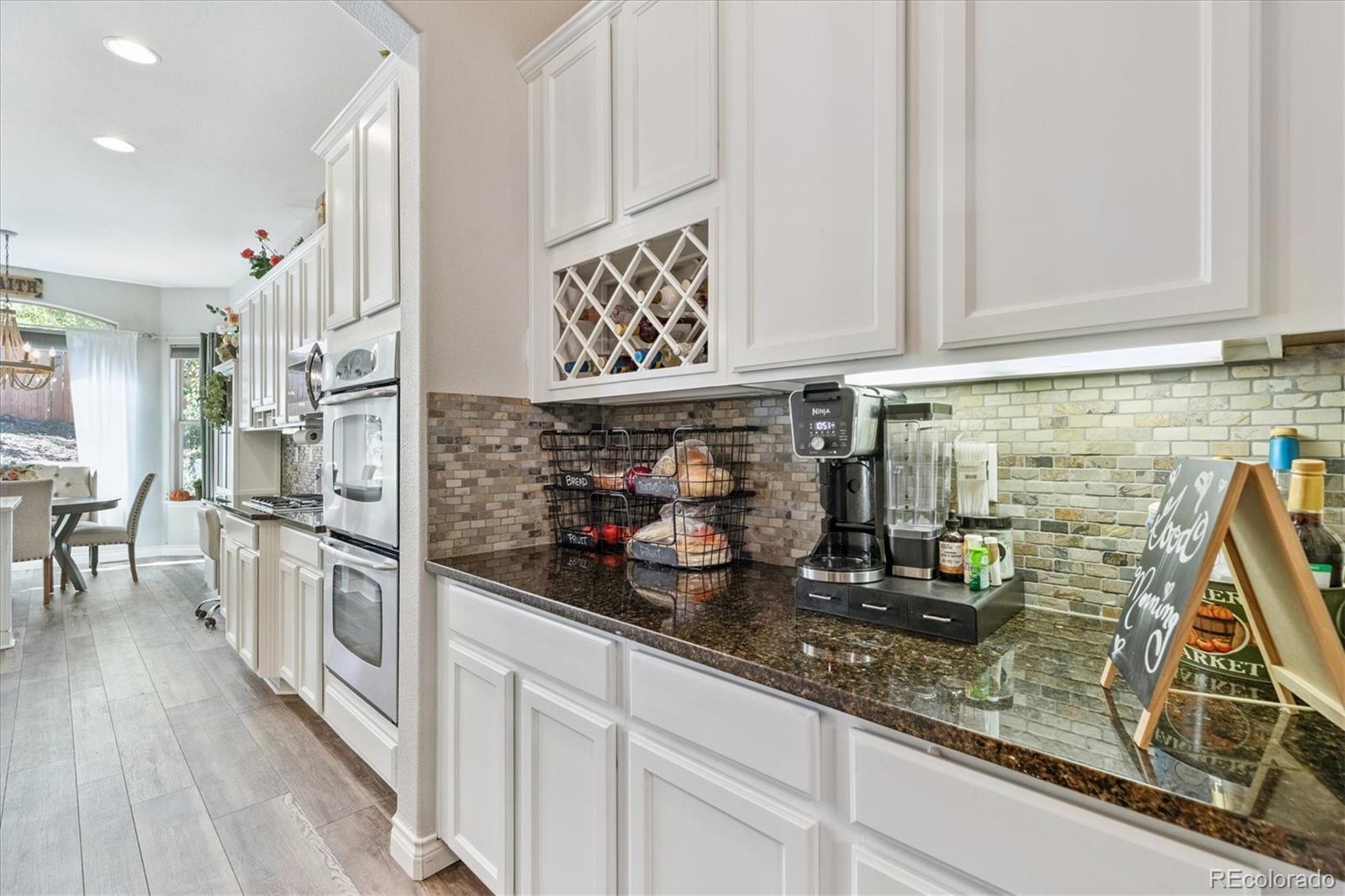 11641 Colony Loop Parker, CO 80138 - Photo 13 of 37 a kitchen with stainless steel appliances granite countertop a lot of counter space and wooden floor