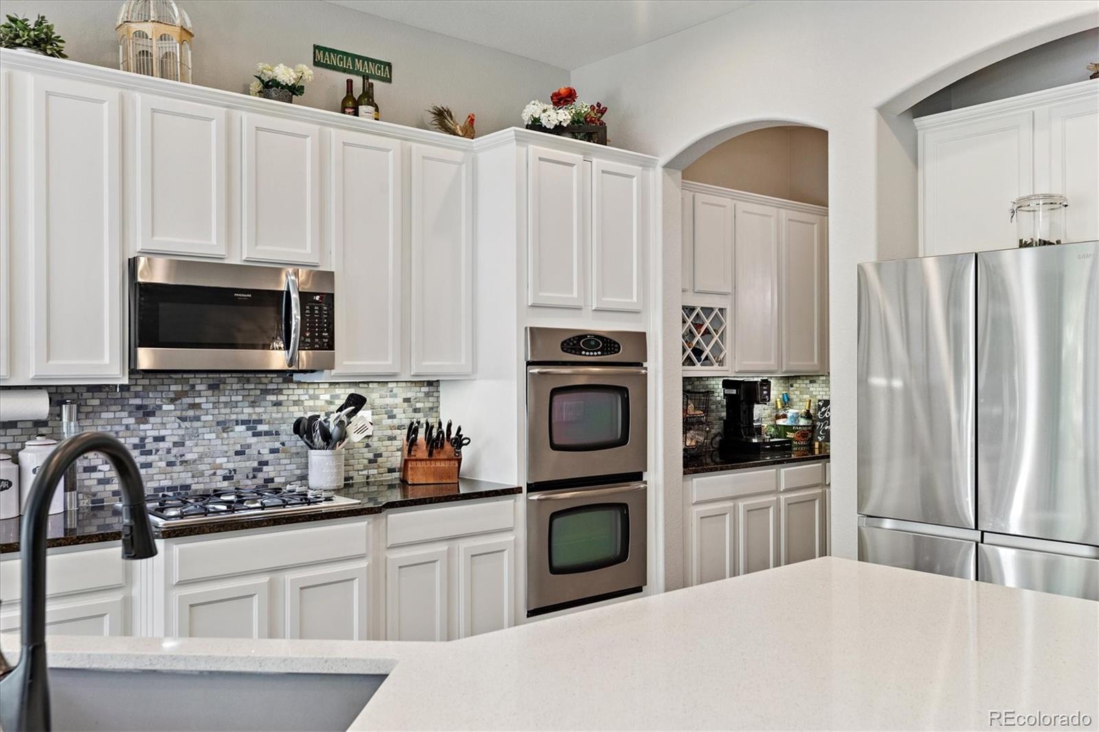 11641 Colony Loop Parker, CO 80138 - Photo 14 of 37 a kitchen with stainless steel appliances a stove microwave and sink