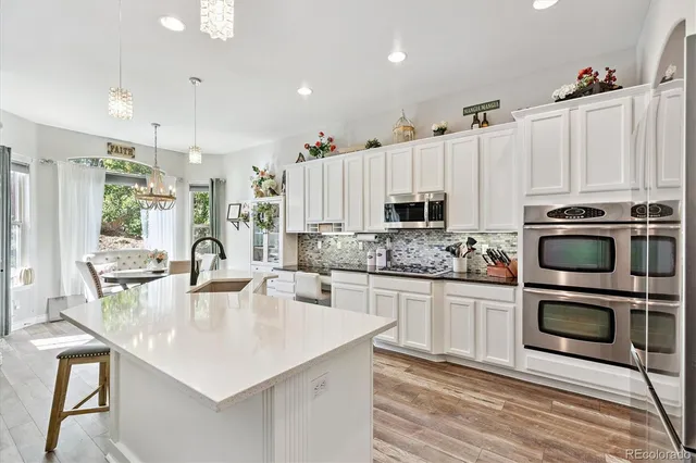 a kitchen with stainless steel appliances a stove a sink a microwave a refrigerator and cabinets