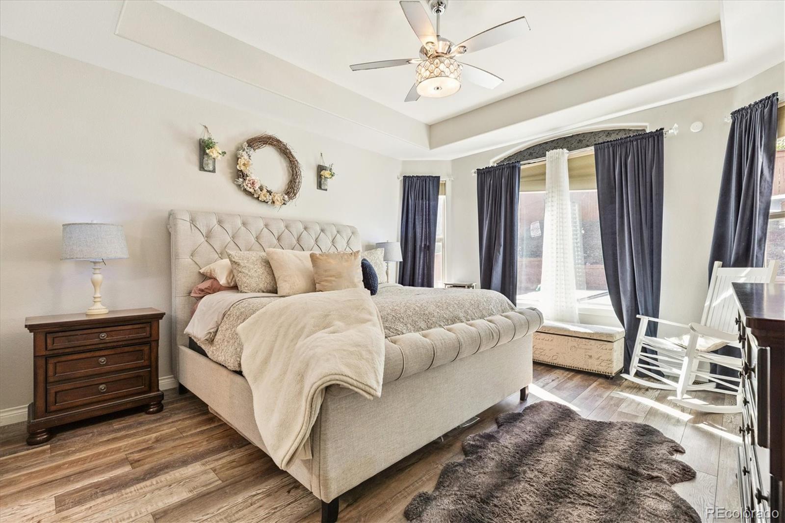 11641 Colony Loop Parker, CO 80138 - Photo 21 of 37 a bedroom with a bed and a chandelier