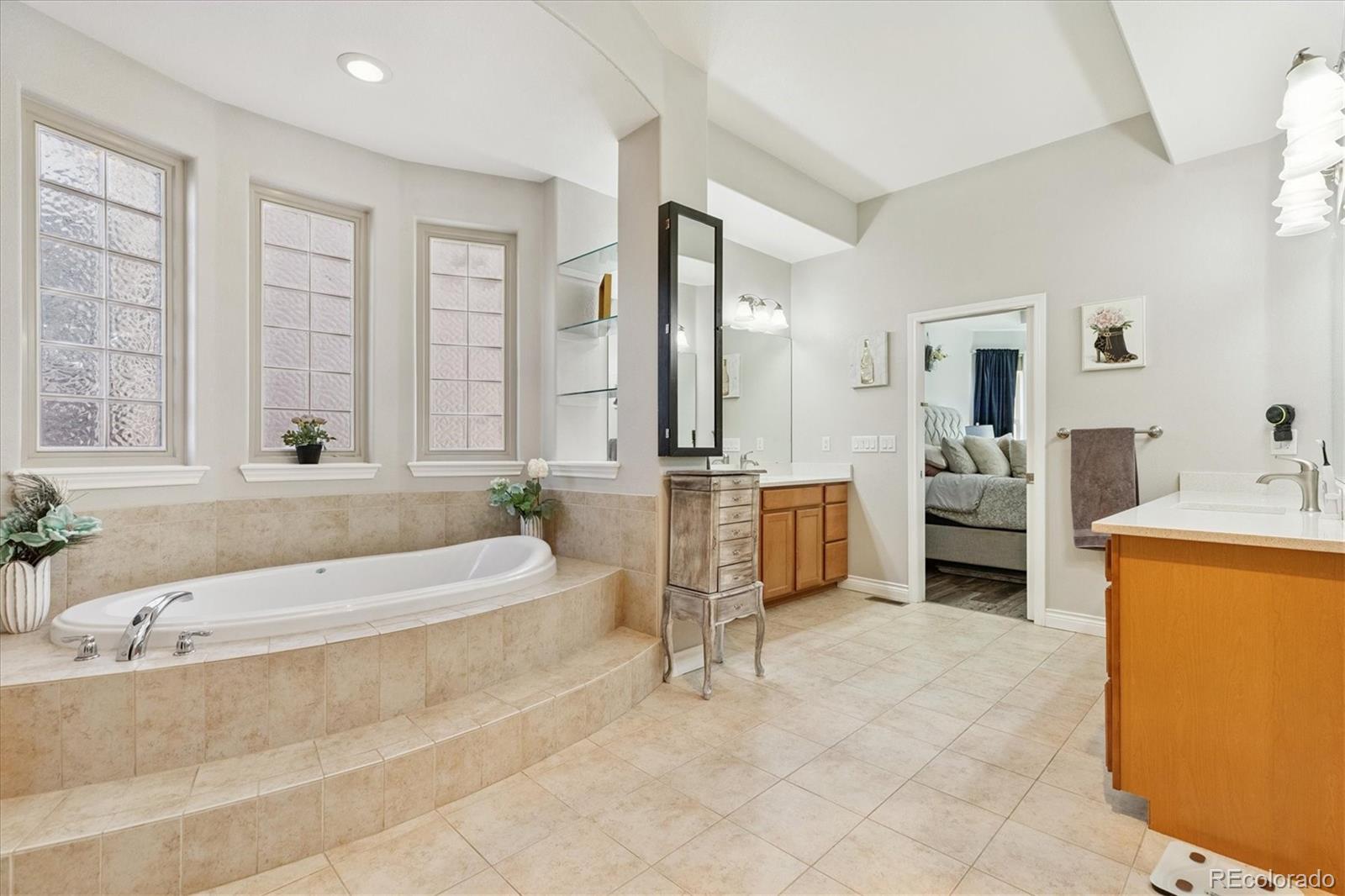 11641 Colony Loop Parker, CO 80138 - Photo 23 of 37 a spacious bathroom with a tub sink and mirror