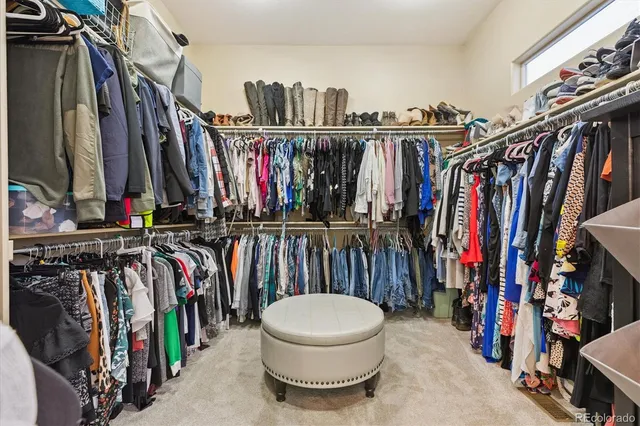 a view of walk in closet with clothes