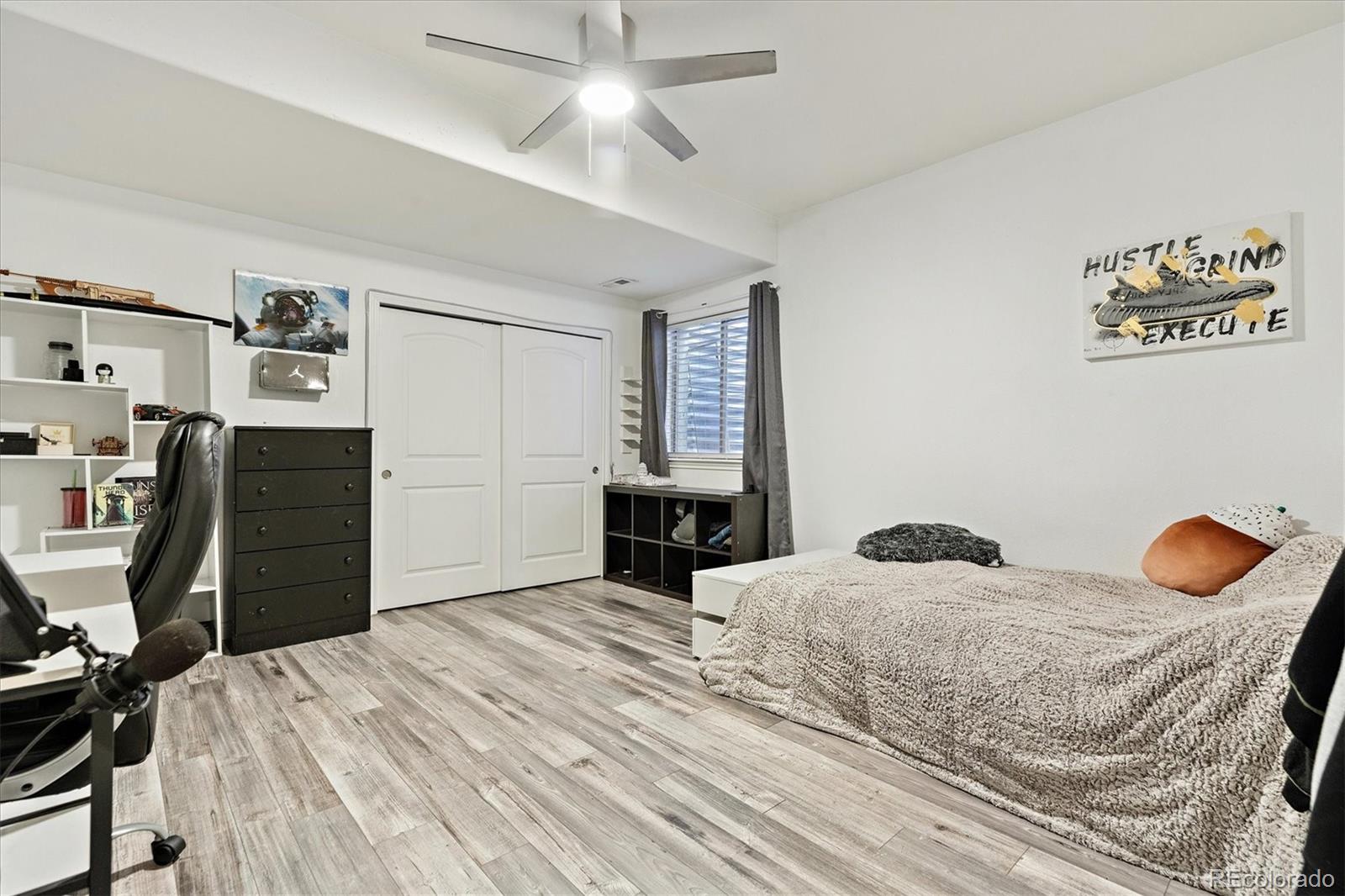 11641 Colony Loop Parker, CO 80138 - Photo 33 of 37 a bedroom with a bed and a chandelier