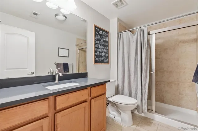 a bathroom with a granite countertop sink toilet a mirror a vanity and shower
