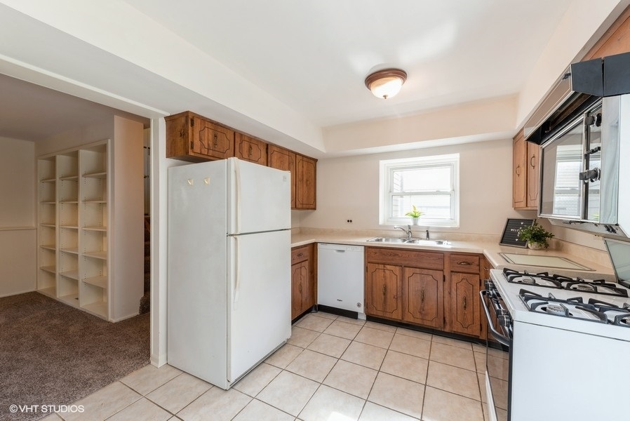 644 Raupp Boulevard Buffalo Grove, IL 60089 - Photo 5 of 23 a kitchen with a stove a refrigerator and a sink