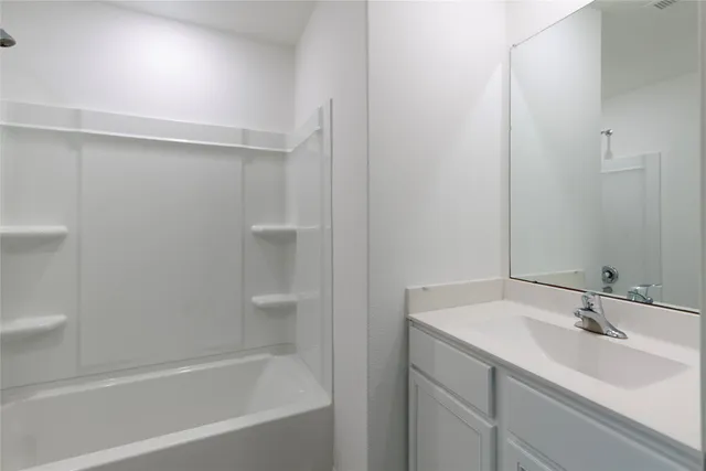 a bathroom with a bathtub sink vanity and toilet