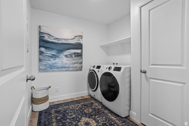 488 West Greenstone Pl Street, Unit 1010 St. George, UT 84790 - Photo 29 of 34 Dedicated laundry area featuring a front-loading washer and dryer, wood-finish flooring, and a built-in wall shelf