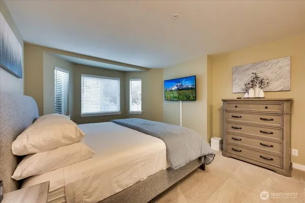 a bedroom with a bed and dresser with mirror