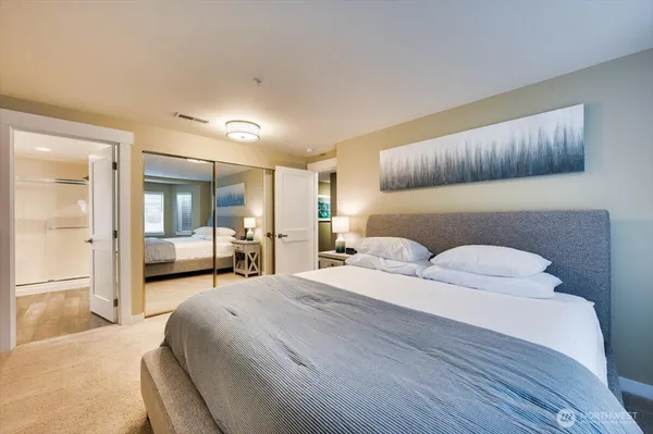 a bedroom with a large bed and a lamp