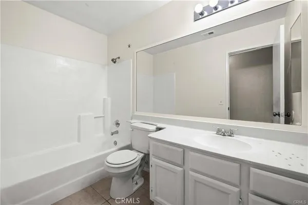a bathroom with a toilet a sink a mirror and a bathtub