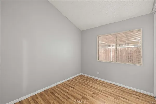 a view of a room with wooden floor and a window