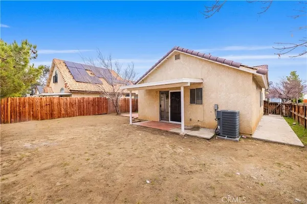 a view of a house with backyard and a tree