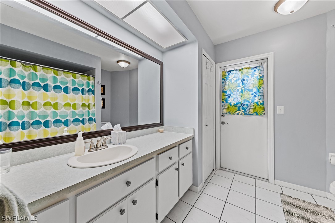 9132 Bryant Road Fort Myers, FL 33967 - Photo 18 of 23 a bathroom with a sink a mirror and a shower