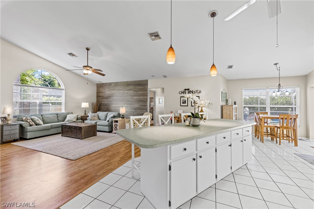 9132 Bryant Road Fort Myers, FL 33967 - Photo 5 of 23 a kitchen with kitchen island granite countertop a stove a sink a dining table and chairs with the floor