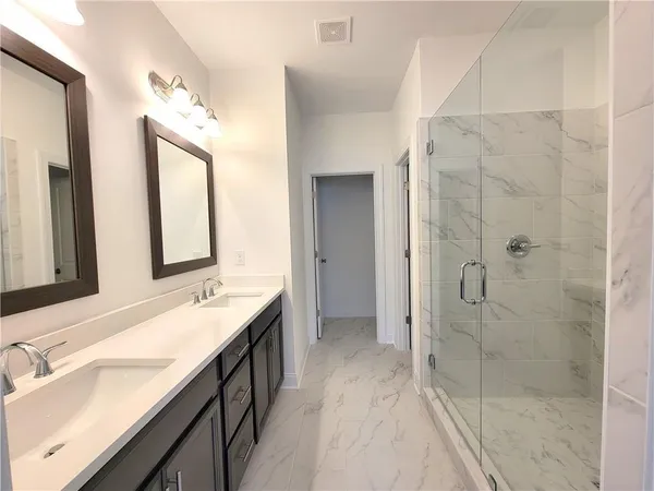 a spacious bathroom with a double vanity sink mirror and shower