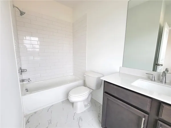 a bathroom with a sink a toilet a mirror and bathtub